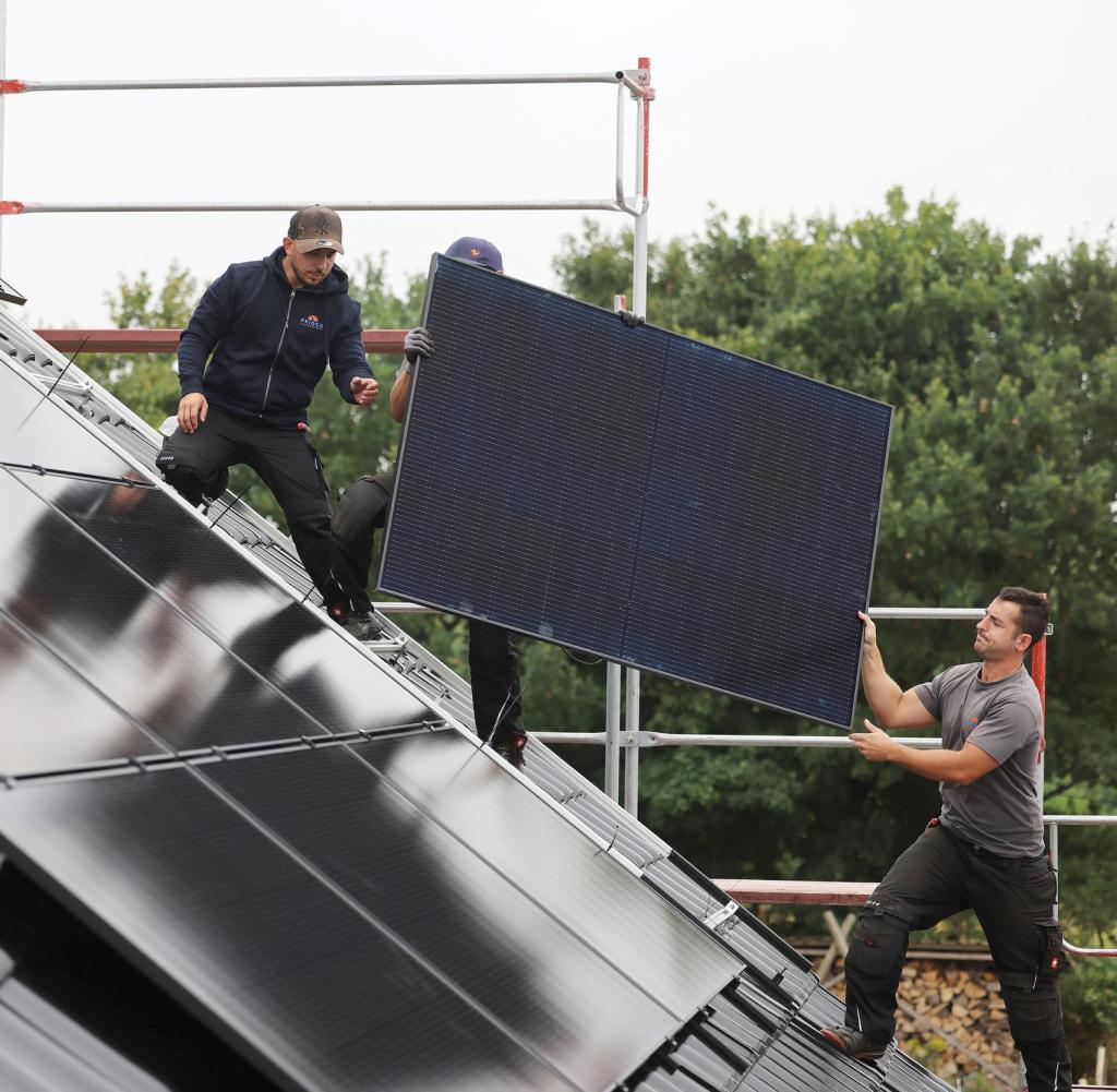 Craftsmen install solar panels on the roof of a residential building.  China is by far the most important supplier for the panels