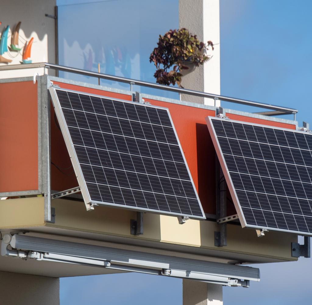 Solarmodule für ein Balkonkraftwerk hängen an einem Balkon. Je nach Bundesland gibt es dazu auch Förderungen
