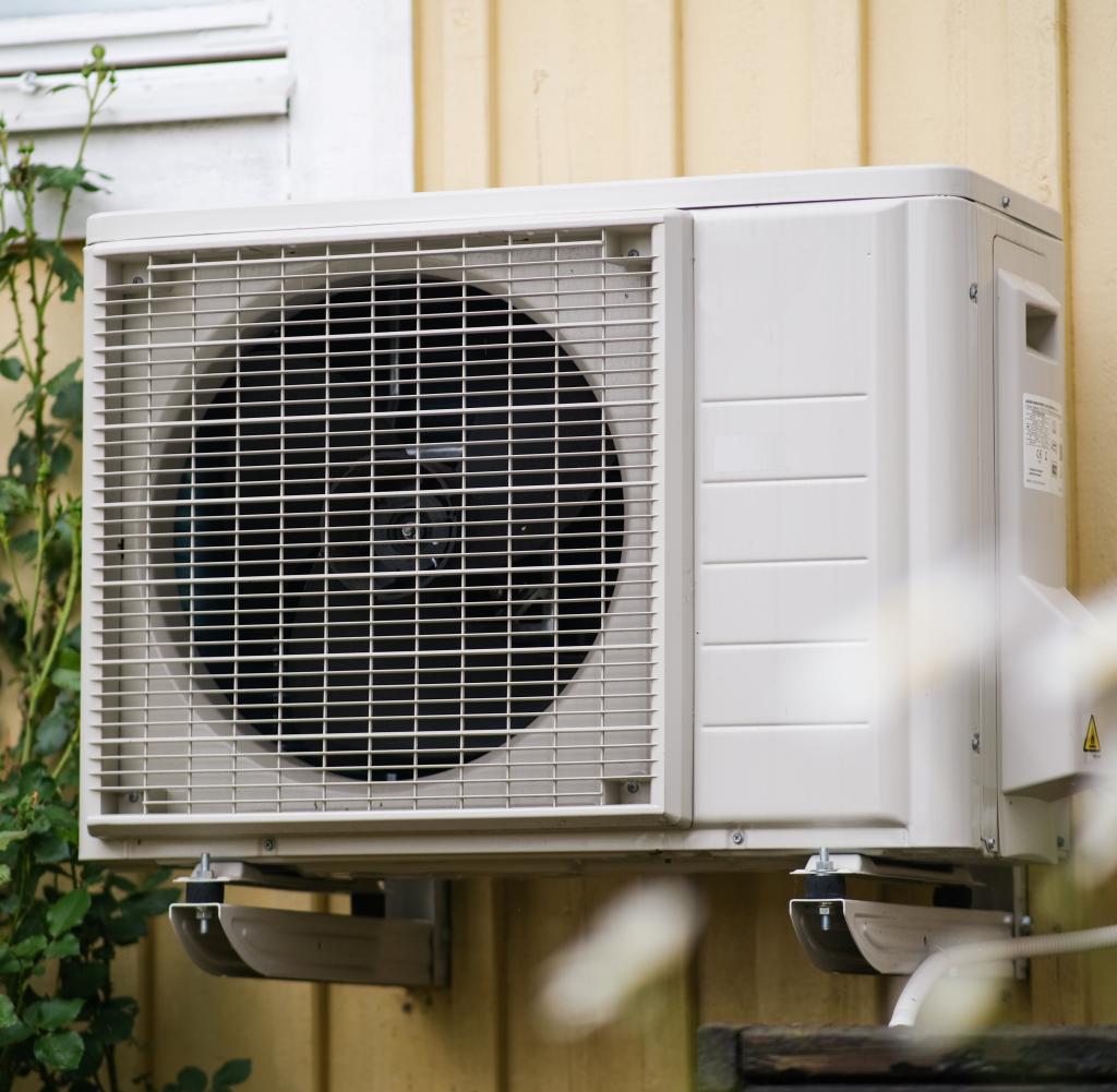 Heat pump on a yellow holiday home in the summer