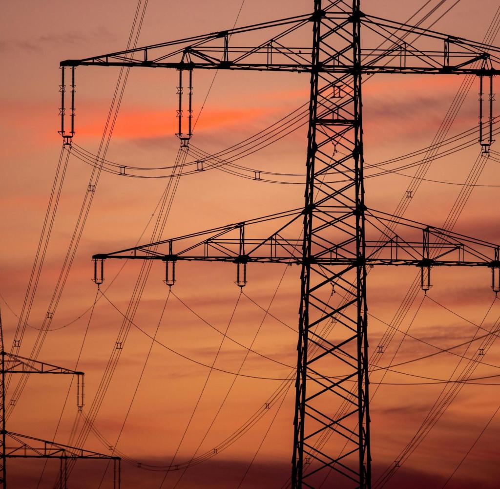 Hochspannungsmast einer Freileitung in der Dämmerung